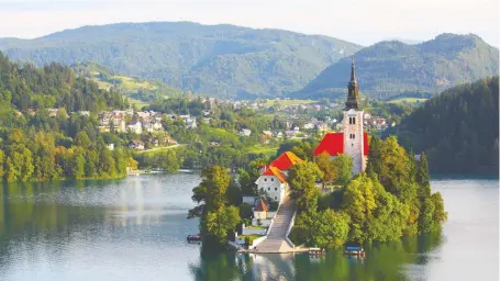  ?? GETTY IMAGES/ISTOCKPHOT­O ?? Lake Bled is home to St. Mary’s Church, nestled on its own little island, with the Julian Alps soaring skyward.