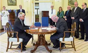  ??  ?? Painful revelation­s: Governor- General of Australia Peter Cosgrove, with Justice Peter McClellan (seated left), signing a document after receiving the final report. — AP