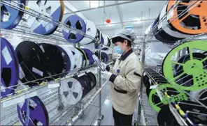  ?? GU HUAXIA / XINHUA ?? A technician works on the production line of a circuit board in a high-tech company in Hai’an, Jiangsu province.