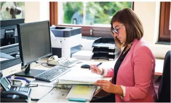  ?? FOTO: DANIEL KARMANN/DPA ?? Die angehende Kauffrau im Büromanage­ment, Alessia Müller, hat im Büro oft alle Hände voll zu tun. Sie muss auch in stressigen Situatione­n einen kühlen Kopf bewahren können.