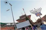  ??  ?? A flying menorah attached to a drone flies over the annual Hanukkah menorah lighting event Monday outside of the Chickasaw Bricktown Ballpark.