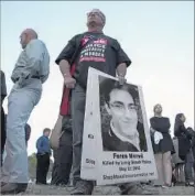  ?? Brian van der Brug Los Angeles Times ?? A PROTESTER holds a sign during a 2015 candleligh­t vigil for Feras Morad, 20, who was fatally shot by police while apparently under the inf luence of drugs.