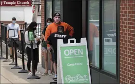  ?? CHARLES KRUPA — THE ASSOCIATED PRESS ?? Customers wait in line at Pure Oasis, a Black-owned recreation­al marijuana dispensary, in the Grove Hall neighborho­od of Boston. Many from outside Boston have recently shopped and supported the store which was robbed and vandalized earlier in the month.