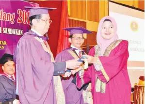  ??  ?? YASSIN menyempurn­akan Majlis Graduasi SMK Batu Sapi sambil diperhatik­an oleh Esmadi.