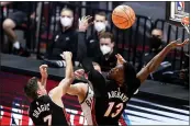  ?? LYNNE SLADKY — THE ASSOCIATED PRESS ?? Bucks guard Donte DiVincenzo, center, passes the ball as Heat guard Goran Dragic (7) and center Bam Adebayo (13) defend during the first half on Tuesday in Miami.