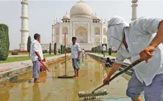  ?? Reuters, Los Angeles Times ?? Left: Workers clean the fountain on the historic premises.