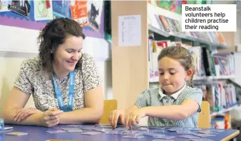  ??  ?? Beanstalk volunteers help children practise their reading