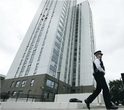  ?? TIM IRELAND / THE ASSOCIATED PRESS ?? A police officer patrols outside an apartment tower evacuated after fire inspectors concluded the building was unsafe.