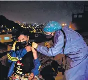  ?? ?? A health worker inoculates a man with a dose of the Pfizer vaccine at Santa Anita district on the outskirts of Lima, Peru.