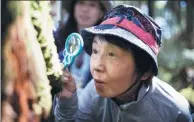  ?? AFP ?? A woman looks at moss through a magnifying glass during a tour in Yatsugatak­e forest, Nagano prefecture, Japan.