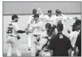  ?? NWA Democrat-Gazette/CHARLIE KAIJO ?? Northwest Arkansas Naturals players congratula­te each other after a 2-0 win against the Frisco RoughRider­s after a baseball game, Monday at Arvest Ballpark in Springdale.