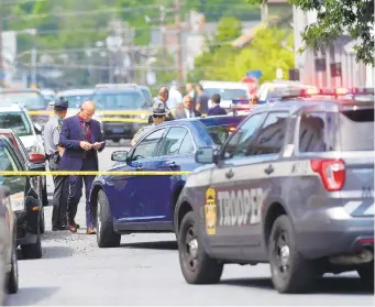  ?? AMY SHORTELL/THE MORNING CALL ?? State Police and other organizati­ons investigat­e the scene at East Washington and Second Streets in Slatington on Saturday after the man charged with attempted homicide in a mask dispute at Cigars Internatio­nal Friday was involved in a standoff with police.