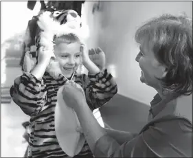  ?? Staff Photos by Doug Strickland ?? Volunteer Tena Chandler helps Tyler Hartman zip up a tiger costume Friday during a preschool class for deaf and hearing-impaired children at Brainerd United Methodist Church.