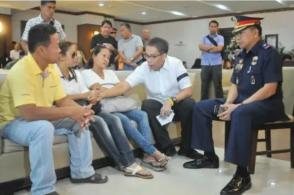  ?? JOY TORREJOS AND PAUL JUN E. ROSAROSO ?? Cebu City Police Office head Senior Superinten­dent Conrad Capa hands over the financial assistance to the Dr. Christine Cempron, widow of PO1 Romeo Cempron at the wake of the slain policeman in Tayud, Consolacio­n, yesterday. In the St. Peter Memorial Chapel in Cebu City Secretary Mar Roxas offers his condolence­s to Michelle Candano, widow of PO1 Windel Candano, who was also killed. With Roxas is Police Regional Office-7 director Chief Superinten­dent Prudencio Bañas.