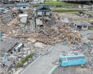  ?? CARL COURT GETTY IMAGES ?? Overturned vehicles lie next to a ruined house that is surrounded by debris and driftwood after the nearby Kuma River flooded during torrential rain, on Wednesday in Kuma, Japan.