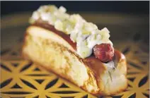  ??  ?? COMFORT FOOD goes glam at the NoMad truck. The Humm dog is wrapped in bacon and garnished with black truff le mayo.