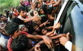  ?? - Reuters ?? HUMANITARI­AN CRISIS: Rohingya refugees stretch their hands for food near Balukhali in Cox’s Bazar, Bangladesh, on September 4, 2017.