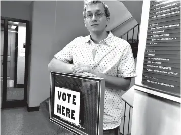  ?? Associated Press ?? ■ In this June 5 photo, Tanner Carlson poses for a photo at an early voting precinct in Bismarck, N.D. The 19-year-old college student calls the state's lack of voter registrati­on "a point of pride" and "one less hoop to jump through."