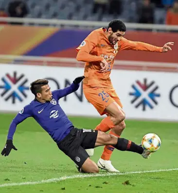  ?? — AFP ?? No you don’t: Johor Darul Ta’zim’s Safawi Rasid going in for a tackle against Shandong Luneng’s Marouane Fellaini during the AFC Champions League Group E match in Jinan on Tuesday.