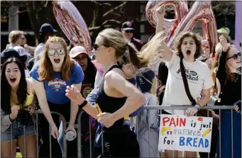  ?? ?? Students lean in cheering as racers pass the “scream tunnel” along the course of the Boston Marathon in Wellesley.