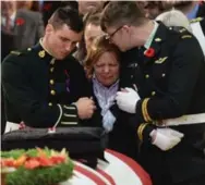  ?? NATHAN DENETTE/THE CANADIAN PRESS ?? Kathy Cirillo is comforted at the coffin of her son Cpl. Nathan Cirillo at his regimental funeral service in Hamilton Oct. 28.