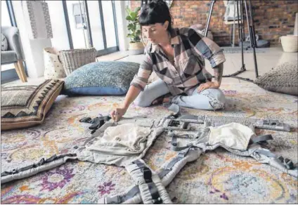  ??  ?? Designing from scratch: Shannon Mclaughlin, who believes that Woolworths copied her unique baby carrier design, keeps busy at her Ubuntu Baba shop in Westlake, Cape Town. Photo: David Harrison