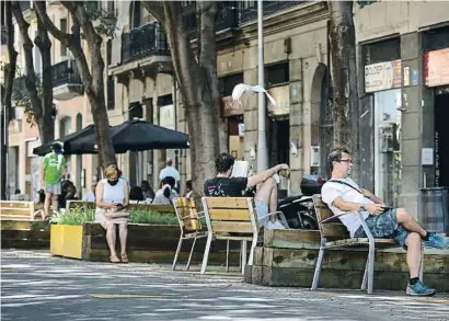  ?? ANA JIMENEZ ?? Varios vecinos buscando sombras en la supermanza­na del barrio del Sant Antoni, ayer