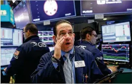  ?? SPENCER PLATT / GETTY IMAGES ?? Traders working on the floor of the NewYork Stock Exchange watched a slumpthat began Friday continue into Monday, erasing the year’s gains in two days.