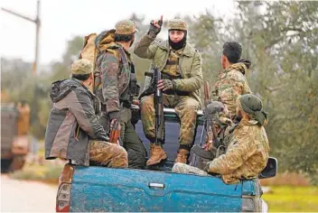  ?? OMAR HAJ KADOUR AFP VIA GETTY IMAGES ?? Turkish-backed Syrian fighters ride in the back of a pickup truck in Sarmin, southeast of the city of Idlib, in northweste­rn Syria, on Friday. The U.N. is calling for an immediate cease-fire in the region.