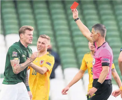  ?? Picture: Brian Lawless/PA ?? Refereee Tasos Sidiropoul­os shows a red card to the Republic of Ireland’s James McClean while Wales and Bristol City midfielder Joe Morrell tries to clam the situation down