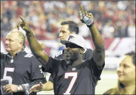  ?? DAVID BARNES / DAVID.BARNES@AJC.COM ?? Ex-Falcons quarterbac­k Michael Vick (7) greets fans in the Georgia Dome at Sunday’s game. He was invited back to join a ceremony during the final regular-season game.