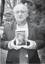  ??  ?? Welid Ali holds a photo of his wife, who died before the family came to Canada.