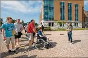  ??  ?? Families and students learn about their college options on a tour at Wright State University.