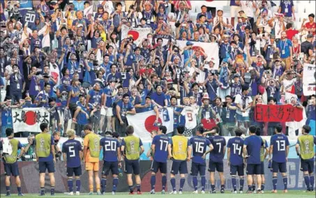  ?? REUTERS ?? After being booed by the crowd throughout the match, Japan players acknowledg­e following their entry into the World Cup knockout stage for the third time.