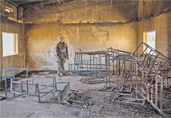  ?? ?? A British soldier in UN headgear amid the charred rubble of a school in Ouatagouna, after the attack by about 80 jihadist gunmen