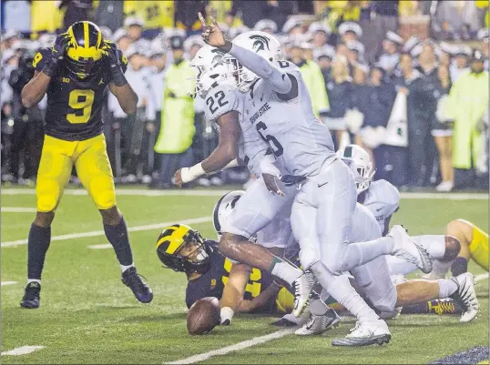  ?? [TONY DING/THE ASSOCIATED PRESS] ?? Michigan State defenders start the celebratio­n after a pass into the end zone on the final play of the game fell incomplete, sealing the Spartans’ win over Michigan.