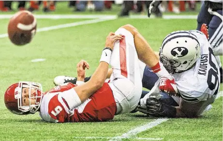 ?? Smiley N. Pool photos / Houston Chronicle ?? UH quarterbac­k John O’Korn watches a lateral he made while under pressure from BYU’s Bronson Kaufusi bounce away and eventually end up going out of bounds during the fourth quarter Saturday.