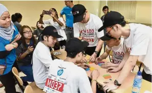  ??  ?? Unusual method: Students building a prototype of a model during a team building game organised by HP Malaysia Manufactur­ing Sdn Bhd at the KDU Penang University College job fair.