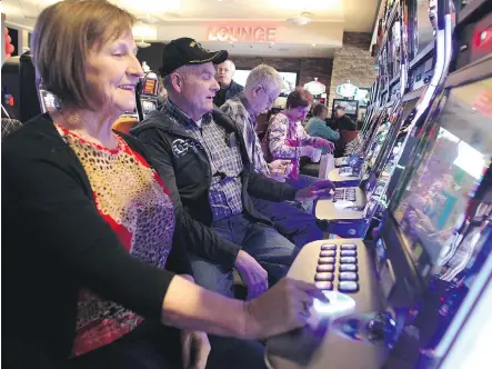  ?? COLLEEN DE NEVE/ CALGARY HERALD ?? Century Downs customers Gladys and Jim Jones were among the first to play the penny slots on Wednesday during the official opening of the new Century Downs Casino and Racetrack in Balzac.