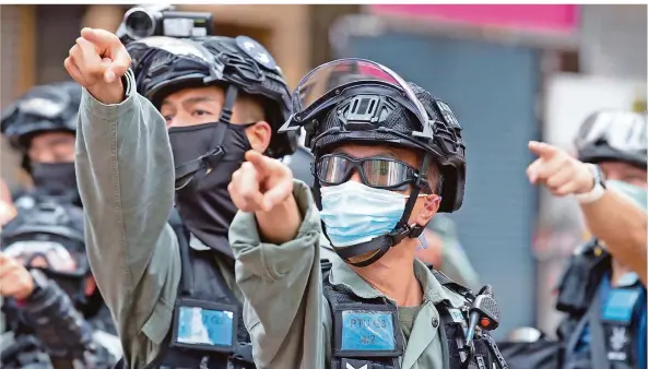  ?? FOTO: RUSSELL/DPA ?? Am ersten Tag unter dem neuen Sicherheit­sgesetz zeigen Polizisten in Hongkong auf Demonstran­ten, die festgenomm­en werden sollen. Diese haben Parolen gerufen, die jetzt illegal sind.