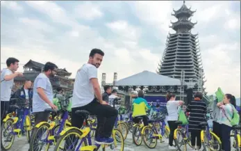  ?? DENG GANG / FOR CHINA DAILY ?? Foreign tourists ride shared bikes to China’s first ethnic-themed outdoor festival held in Rongjiang, Guizhou province, earlier this year. The festival involves a combinatio­n of sports and tourism with characteri­stics of Dong and Miao ethnic groups.