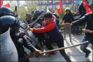  ?? (AP/Niranjan Shrestha) ?? Pro-monarchy demonstrat­ors clash with riot police Monday in Kathmandu, Nepal.
