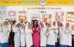  ??  ?? Puan Siti Aidah Rosli (tengah) bersama-sama pelajar pada sesi pembelajar­an di kelas Abad 21.