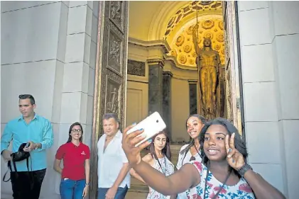 ?? AP ?? Selfie. Turistas toman fotografía­s en el ingreso al restaurado Capitolio Nacional cubano en La Habana.