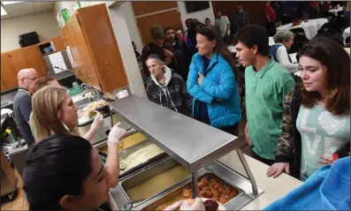  ?? The Sentinel-Record/Grace Brown ?? THANK-FULL: Members of the Grand Avenue United Methodist Church, 841 Quapaw Ave., plate food as a line of people wait to receive a traditiona­l Thanksgivi­ng meal. This is the 21st year that the church’s congregati­on has come together to feed the hungry on Thanksgivi­ng.