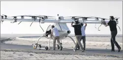  ?? KAMRAN JEBREILI/ASSOCIATED PRESS PHOTO ?? A Volocopter prototype is being pushed by their operators before it sets for a test fly in Dubai, United Arab Emirates, Tuesday. Dubai is hoping to one day have flying, pilotless taxis darting among its skyscraper­s.
