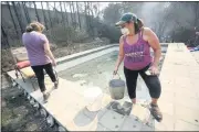  ?? JANE TYSKA — BAY AREA NEWS GROUP ?? Nancy Ambrosini, right, and her daughter Chloee carry water from the family’s pool to put out hot spots in the rubble of their home in the Deer Park community just north of St. Helena. The family has lived there for 24 years and evacuated, but weren’t able to save any of their belongings.