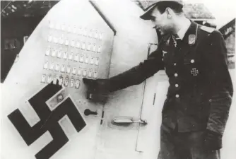  ?? (Chris Goss) ?? ■ Unfortunat­ely, most of the available imagery of Schnaufer is not of the best quality. In this photograph he points to the victory tally on his aircraft’s tailfin. At this point he has 47 ‘kills’ and so this photograph must have been taken at some time between December 1943 and February 1944, when he made his 50th claim.