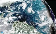  ??  ?? This enhanced satellite image made available by NOAA shows Tropical Storm Florence, center, in the Atlantic Ocean on Saturday, Sept. 8, 2018 at 2:45 p.m. EDT. (NOAA via AP)