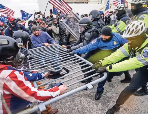  ??  ?? Partidario­s de trump intentan atravesar una barrera policial en el Capitolio de Washington, el pasado 6 de enero